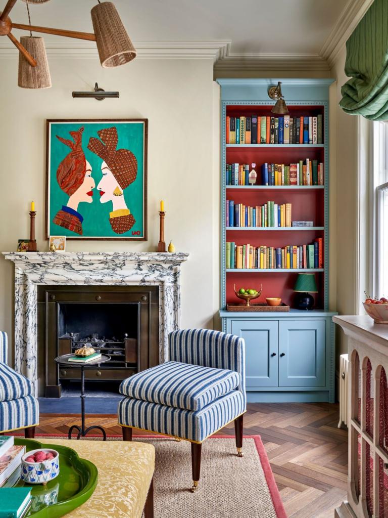 Salon élégant avec bibliothèque peinte en bleu et rouge apportant profondeur et caractère à la pièce.